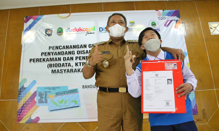 Plt Walikota Bandung Yana Mulyana saat memberikan dokumen kependudukan kepada penyandang disabilitas.
